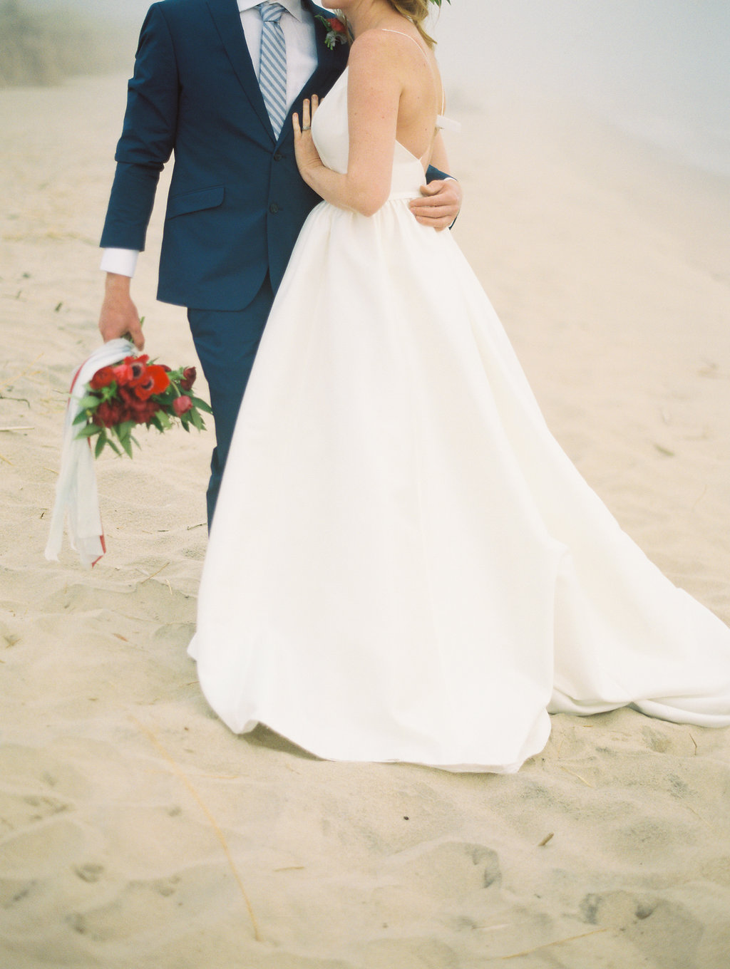 Couple hugging during their Lake Michigan wedding on the beach