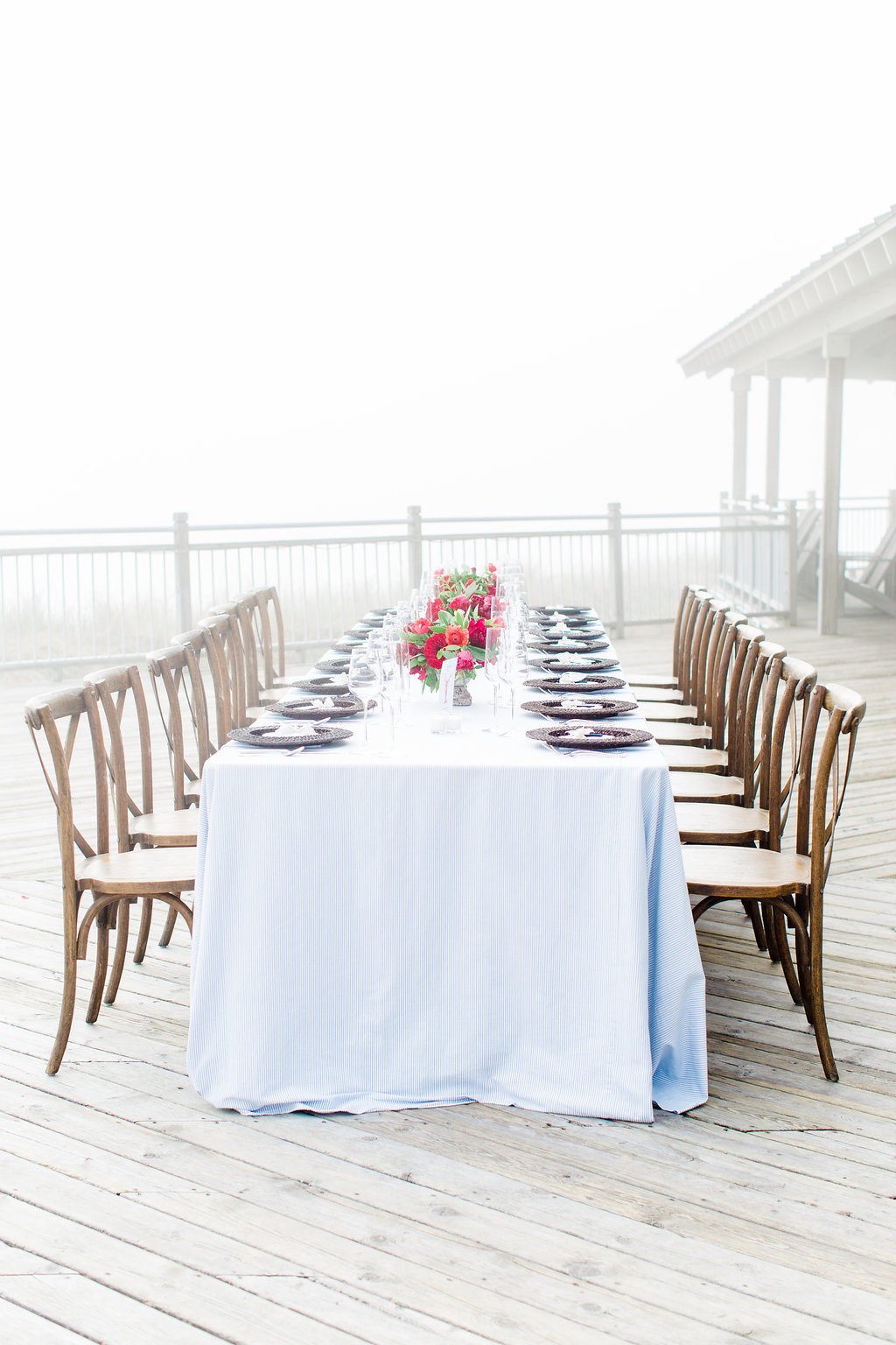 Table set on a deck for a misty lakeside wedding