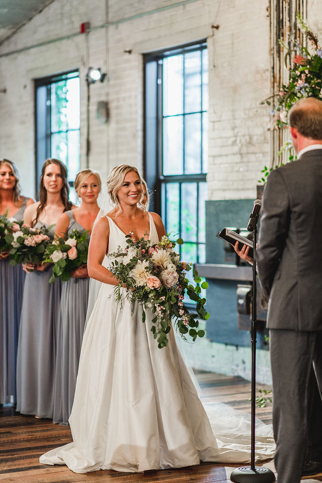 Bride smiling at her groom while exchanging vows