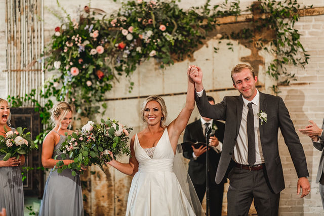 Bride and groom hand in hand receding down aisle