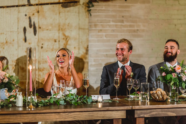 Bride and Groom clapping at head table during speech 