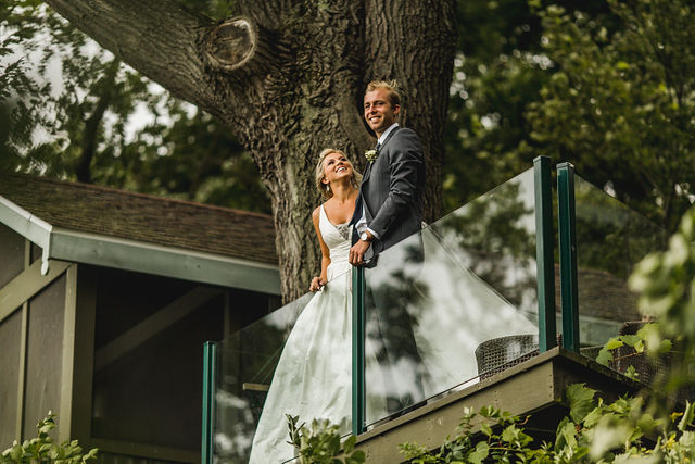 Bride and groom smiling on balcony before Southwest Michigan wedding 