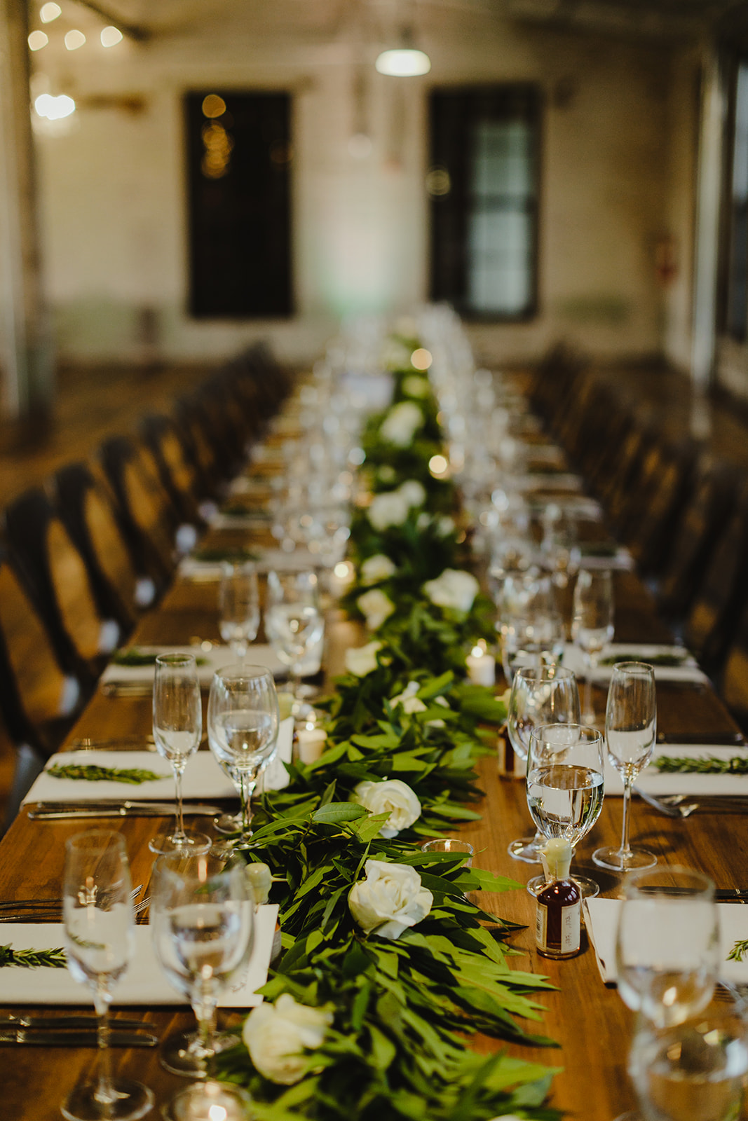 Tables set for greenery for a Journeyman Distillery wedding