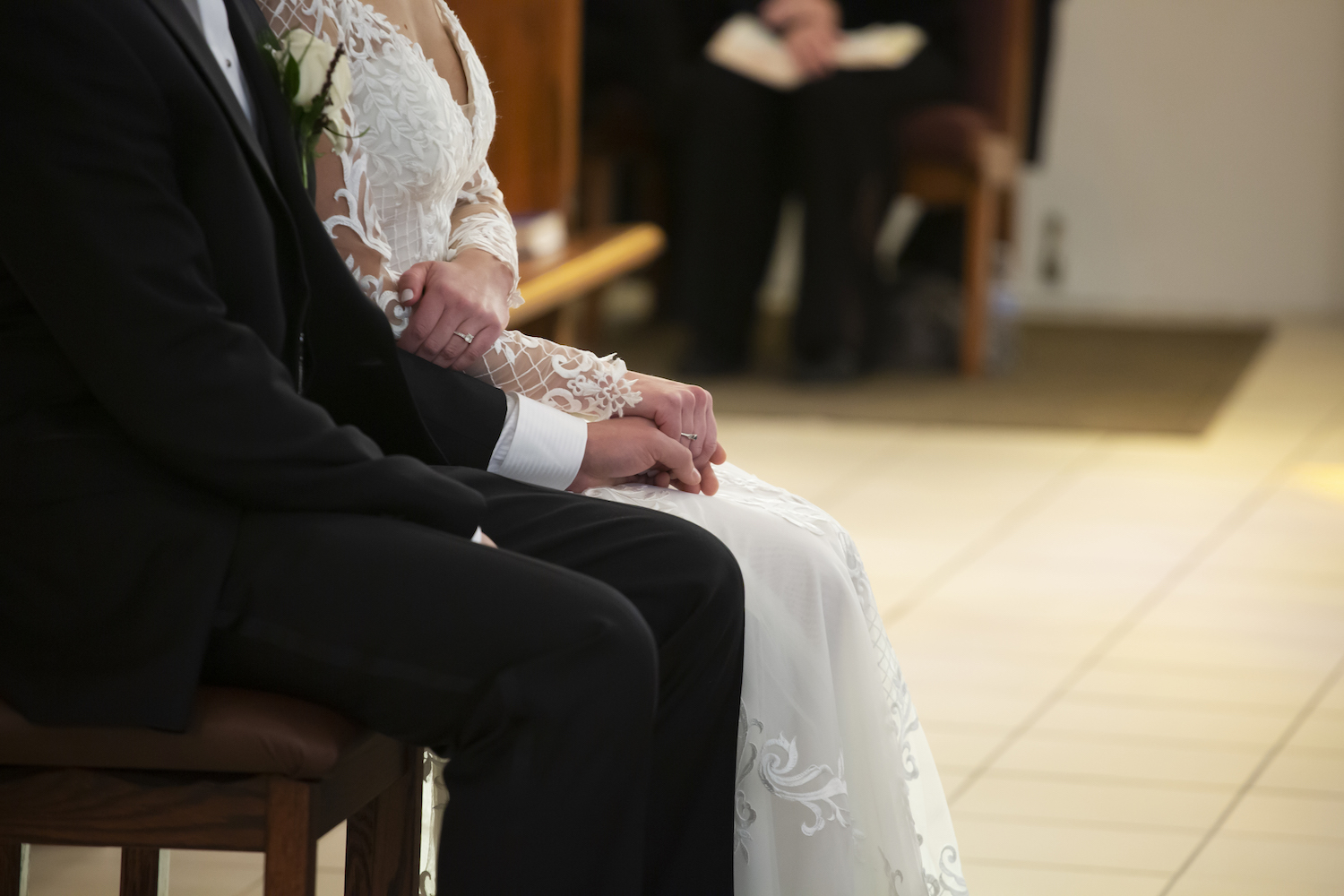 Bride and groom holding hands at alter
