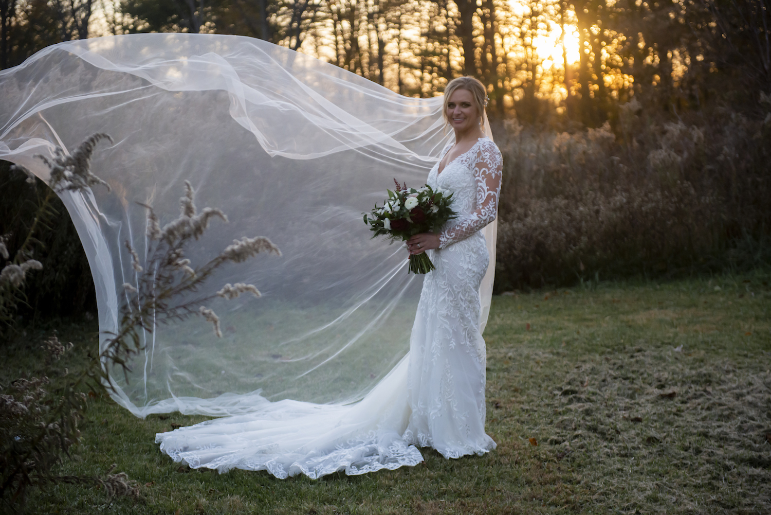 Bride's veil flowing in field for rustic Michigan wedding