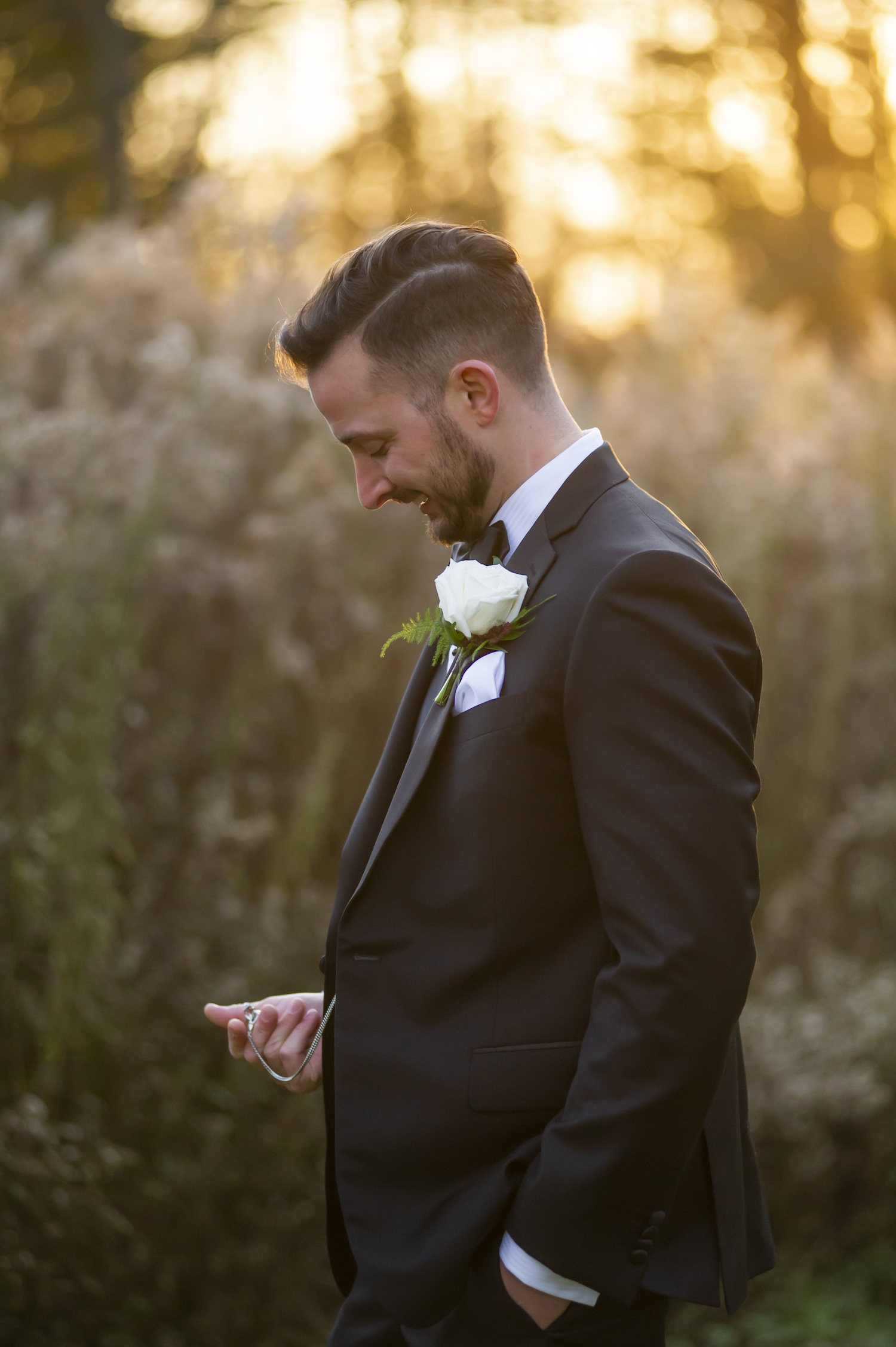 Groom smiling at pocket watch