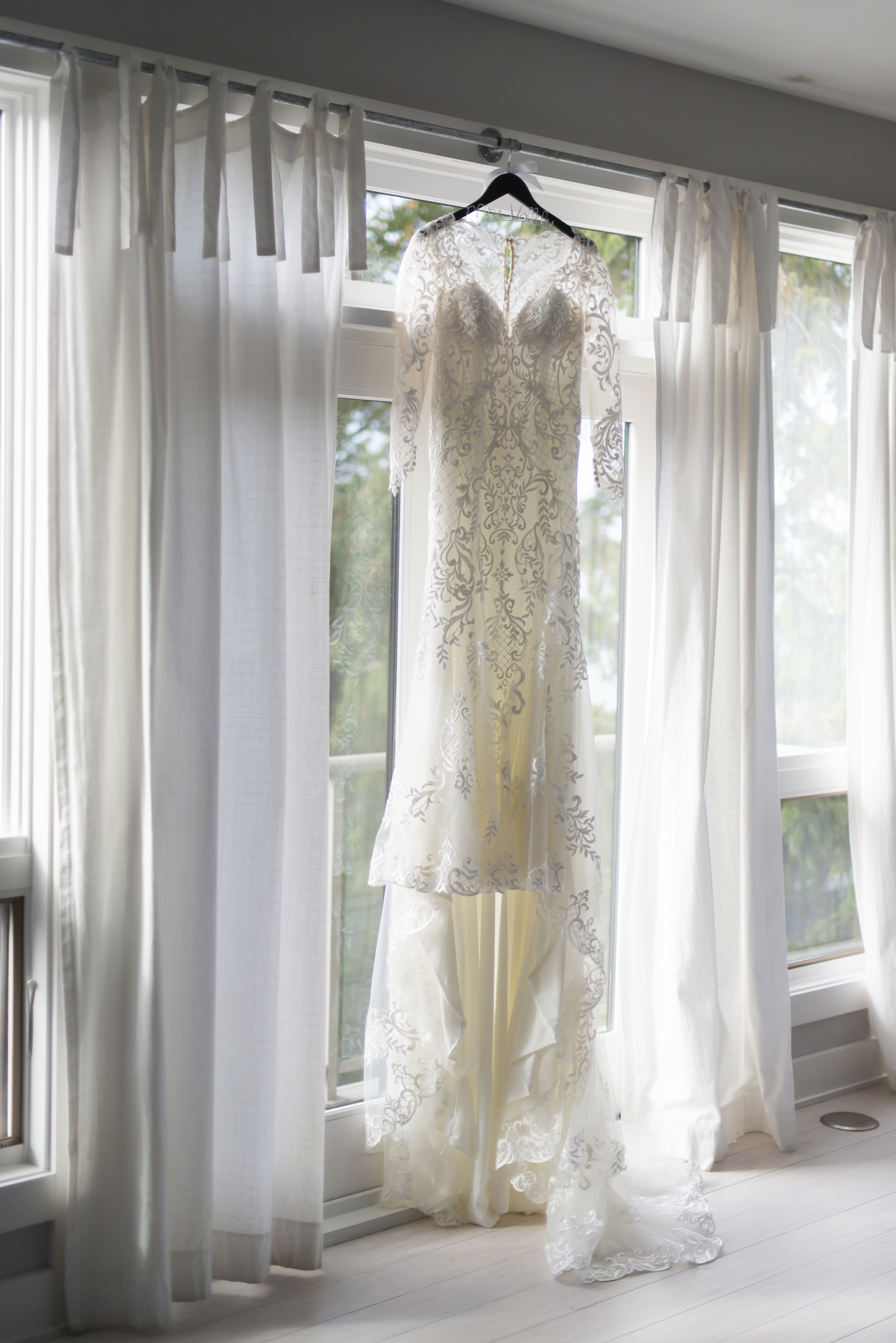 Bridal gown hanging before rustic Michigan wedding