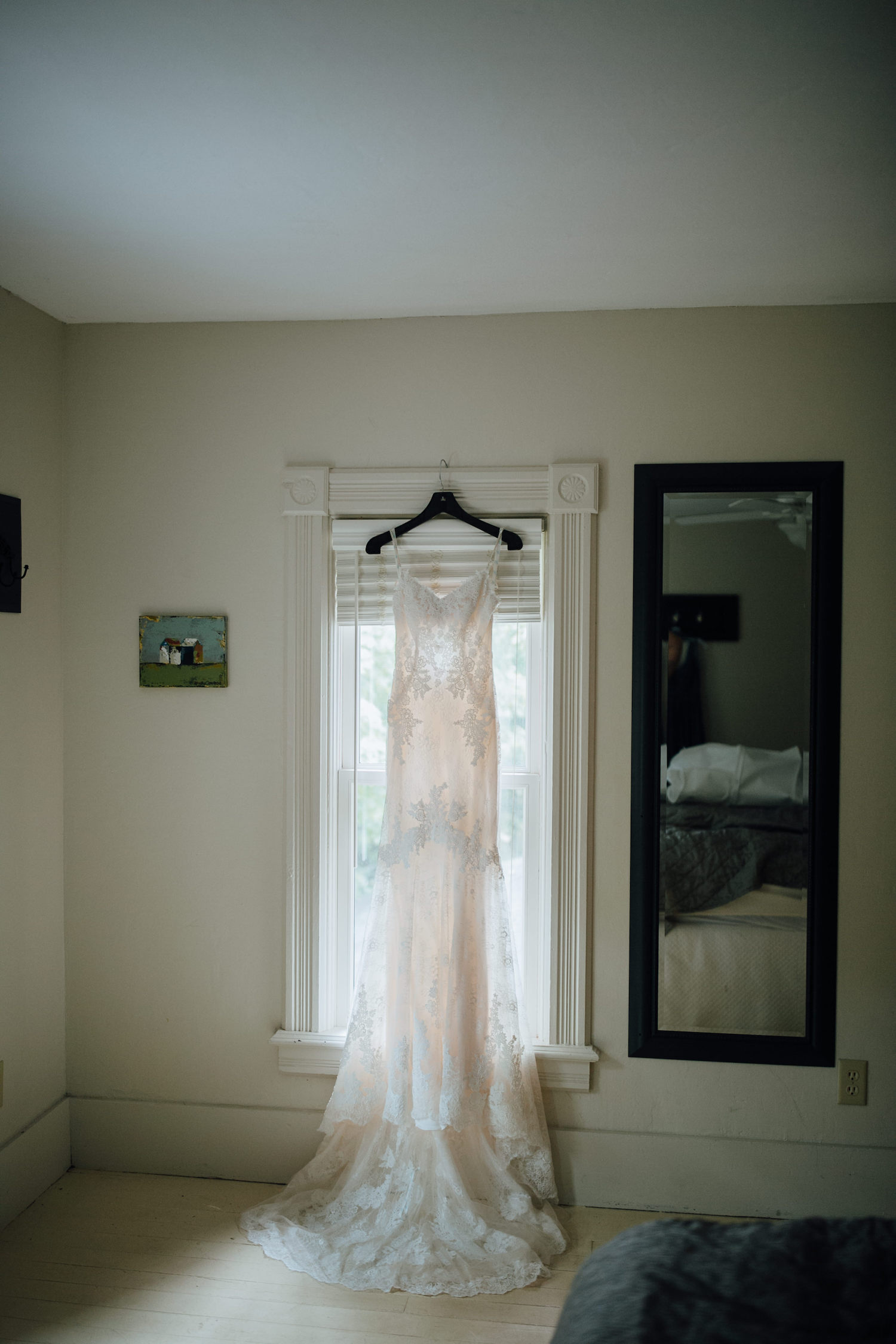 Bride's dress hanging on window at Aurora Cellars wedding