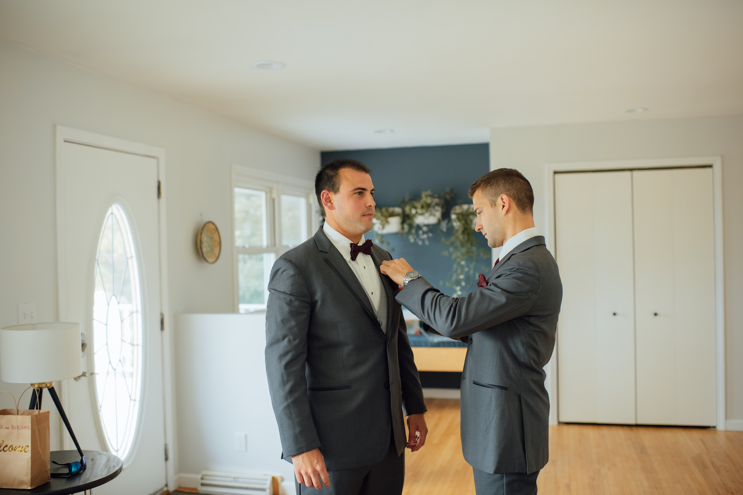 Groom helping groomsman get ready