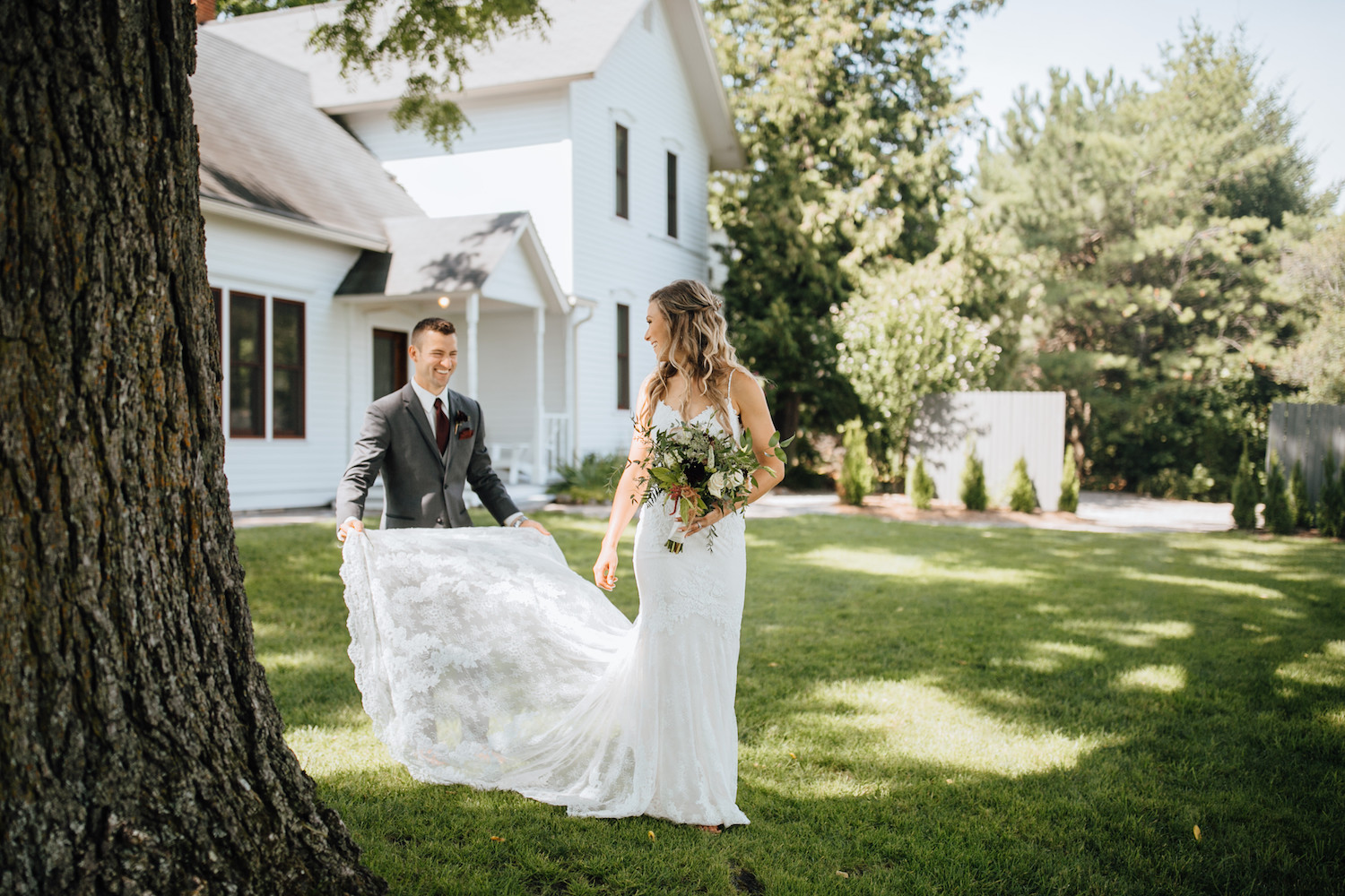 Groom helping bride with dress at Aurora Cellars wedding