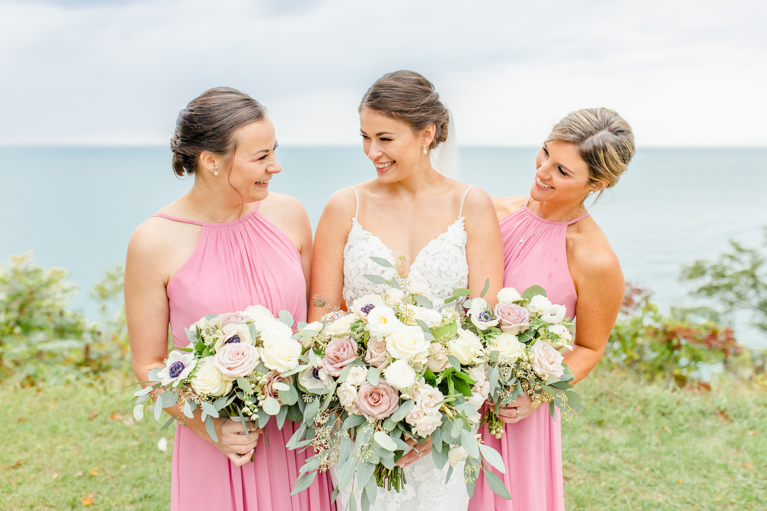 Bride and bridesmaids smiling at the lakehouse wedding