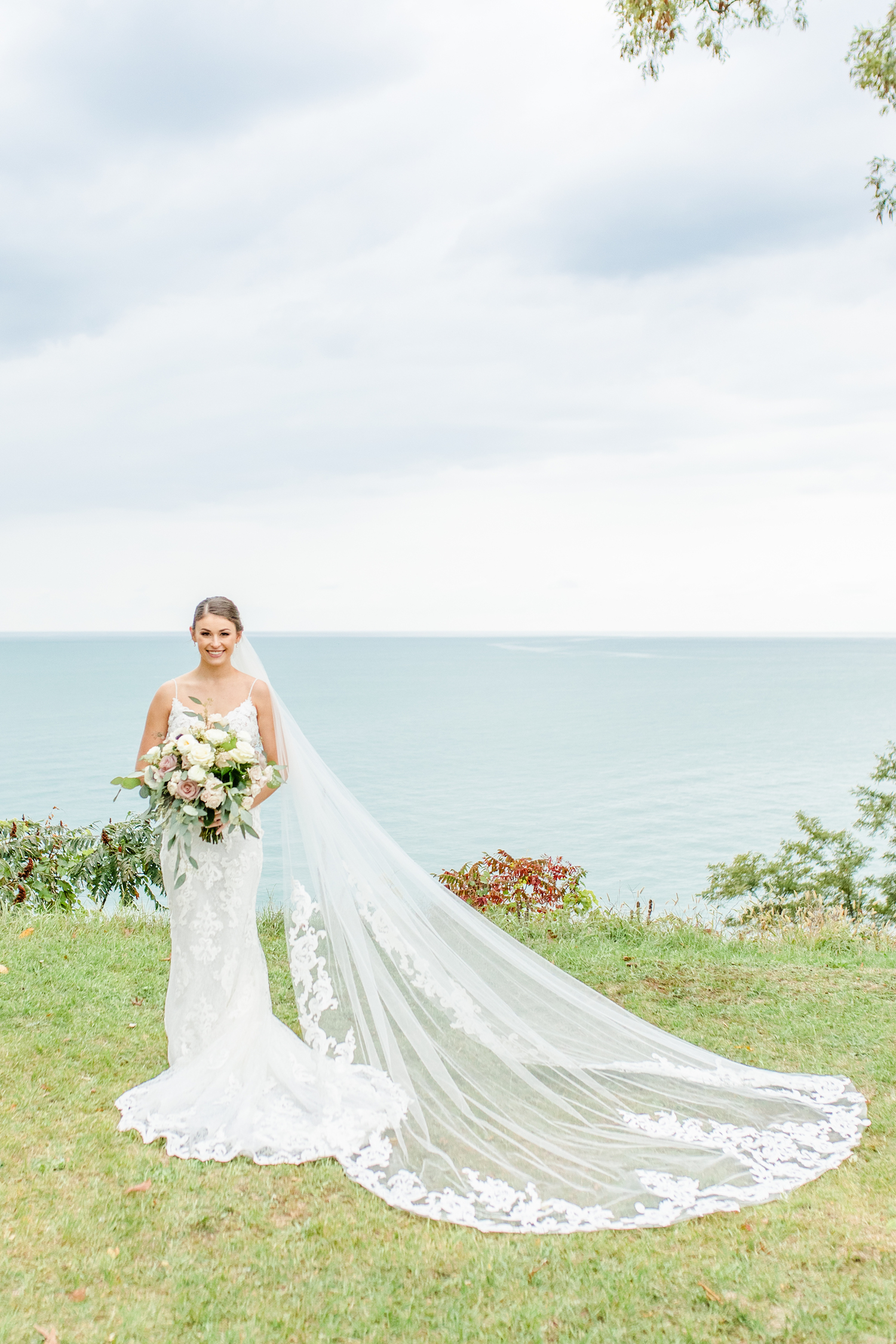 Bride standing by lake after the lakehouse wedding