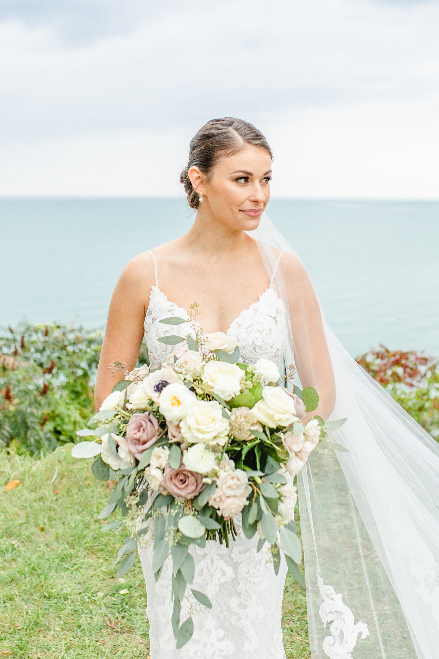 Bride looking off holding bouquet at the lakehouse wedding