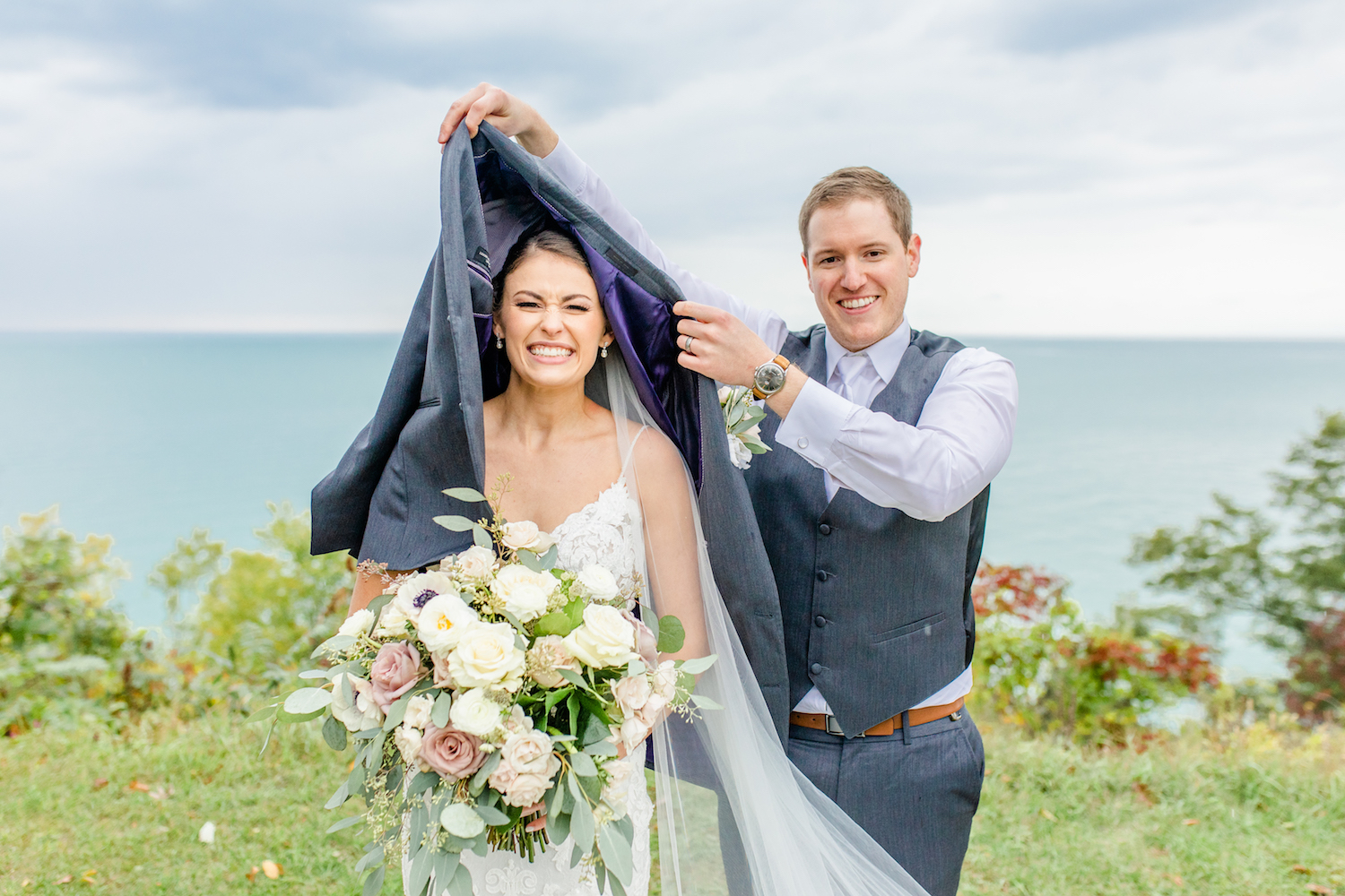 Groom covering bride at their lakehouse wedding