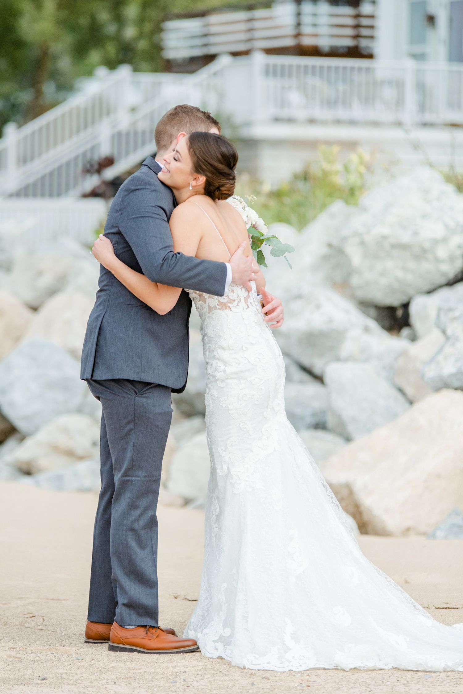 Bride and groom hugging at the lakehouse wedding