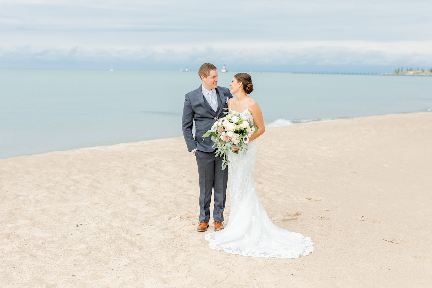 Bride and groom smiling at beach of the lakehouse wedding