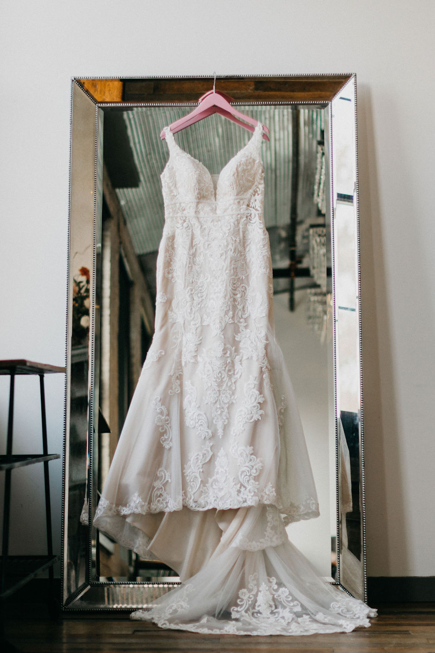 Wedding gown hanging in front of mirror