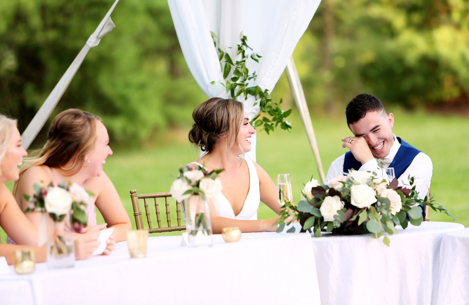 Bride and groom smiling at the head table