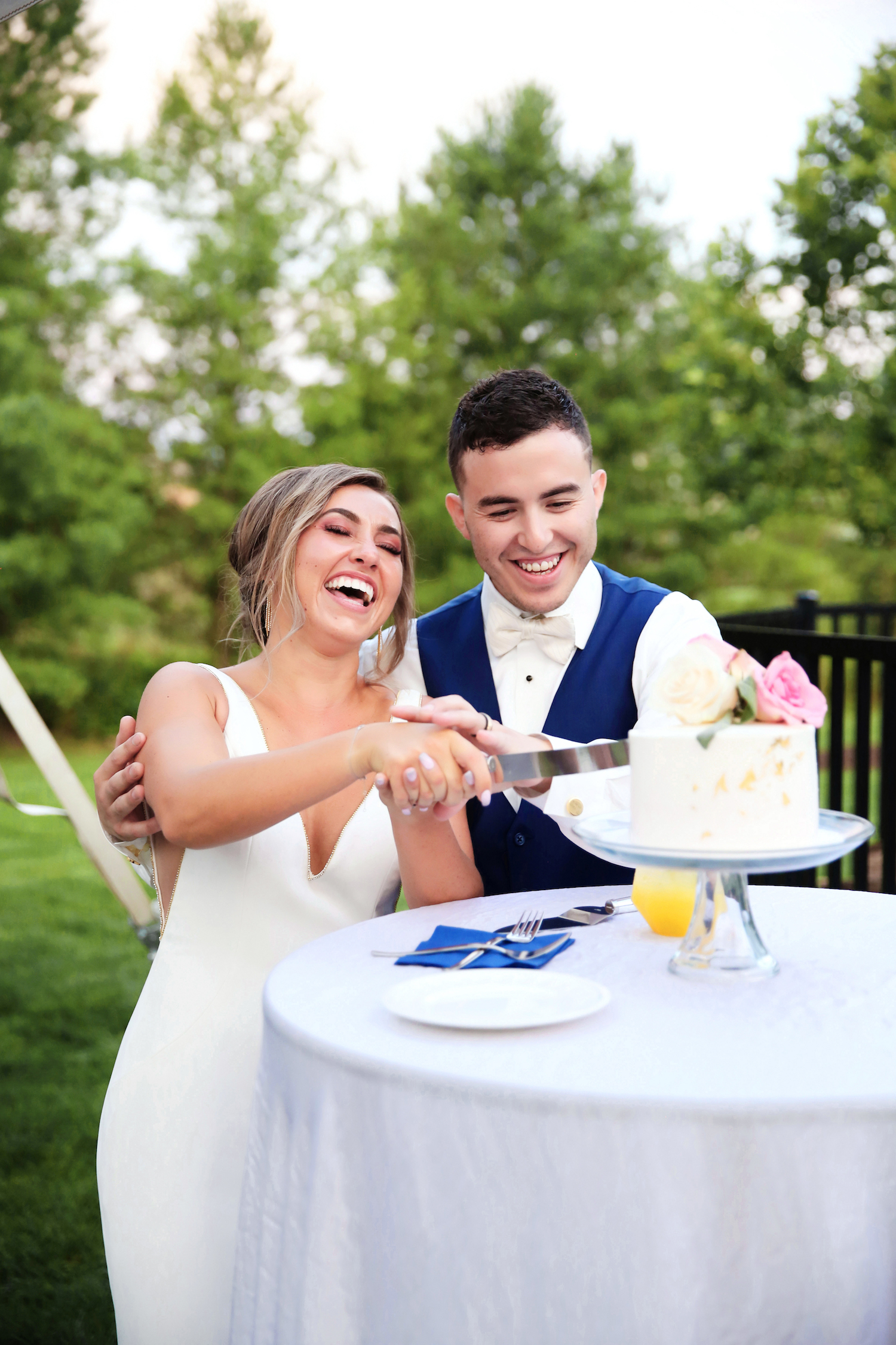 Bride and Groom smiling while cutting their cake