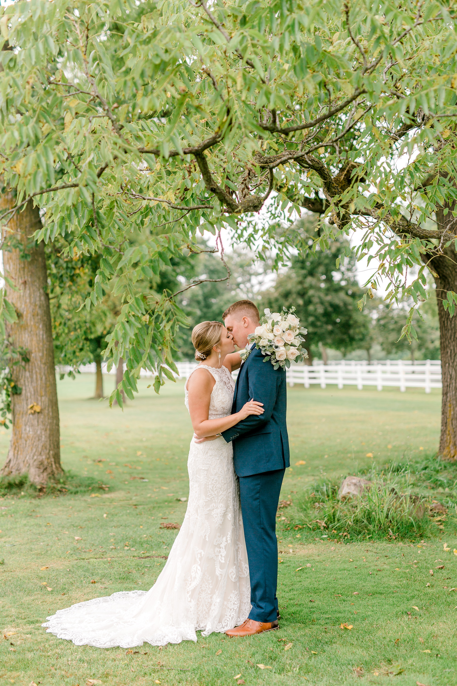 Bride and Groom kissing under tree