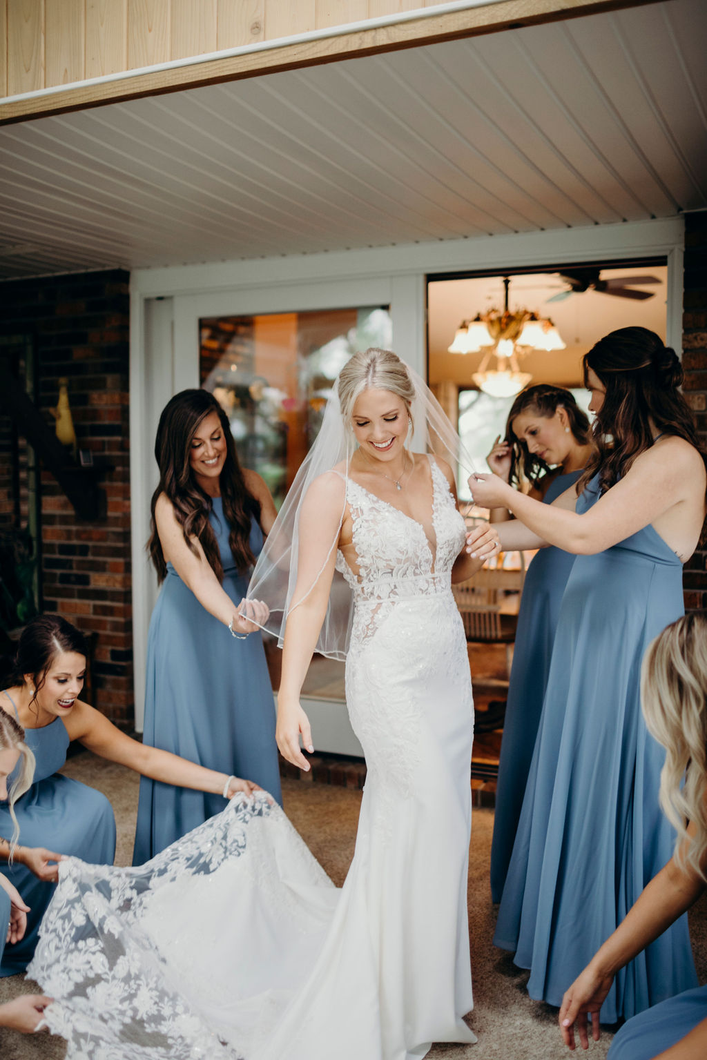 Bridesmaids smiling at brides gown