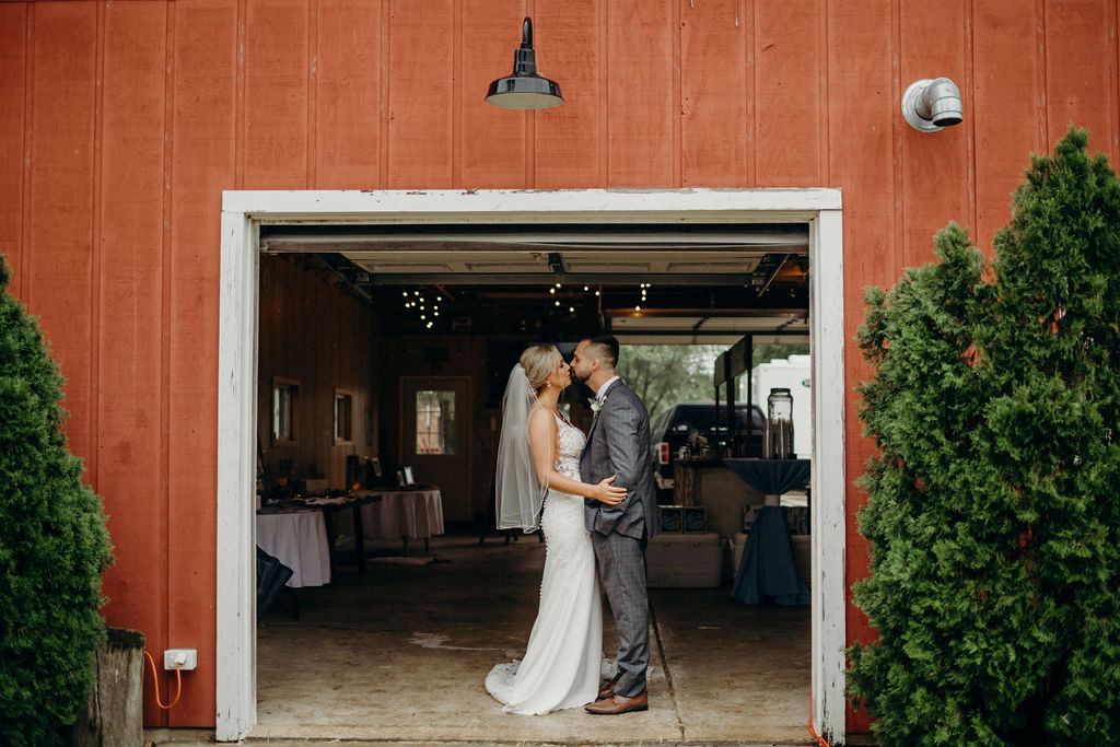 Bride and groom kissing in front of barn of Frankfort, IL Wedding