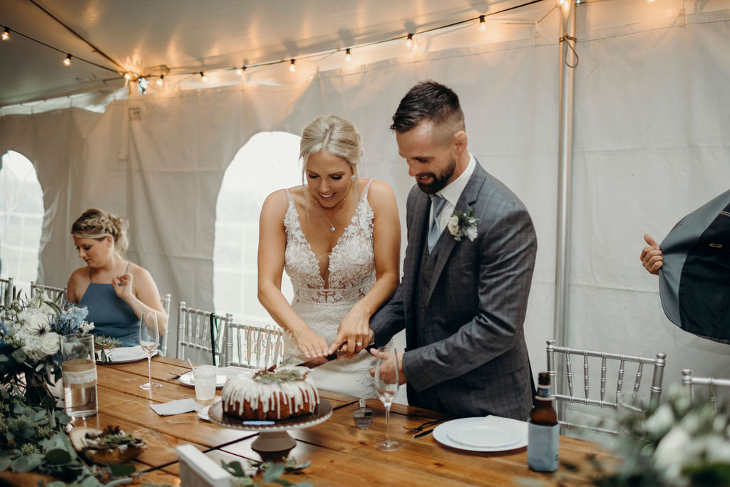 Bride and groom smiling cutting cake