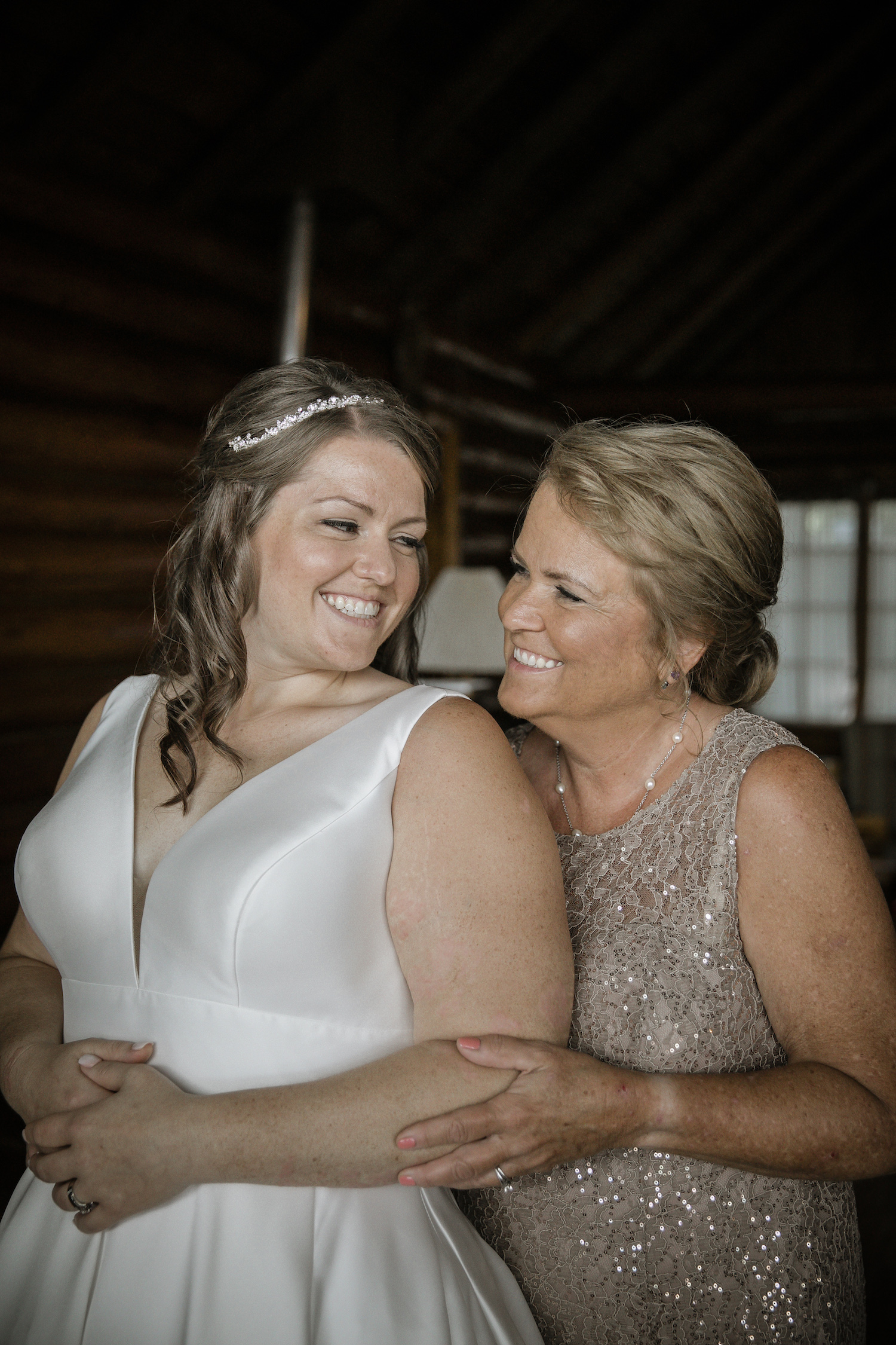 Bride and mother of bride smiling at each other