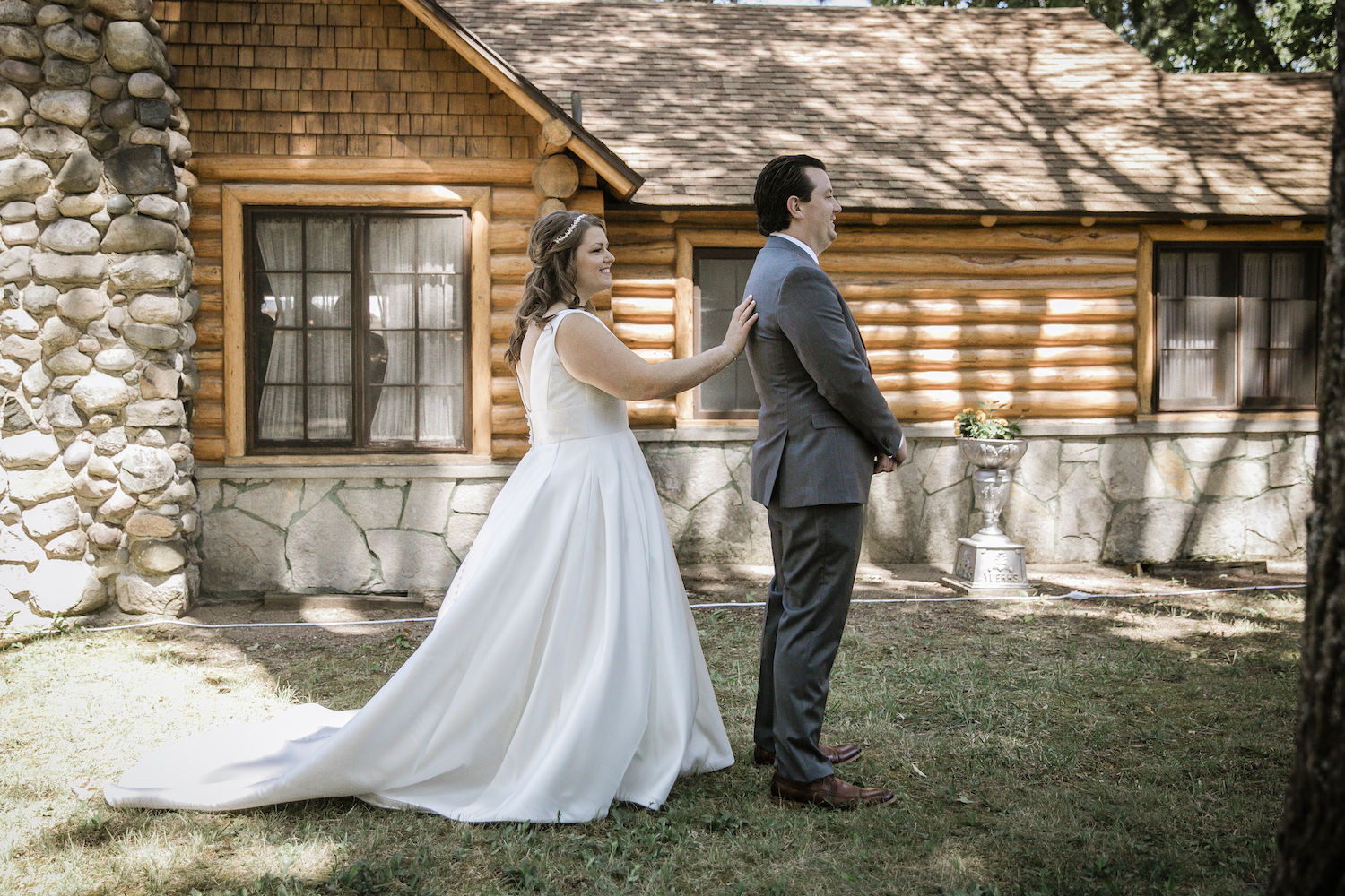 Bride tapping on grooms shoulder before Higgins Lake wedding