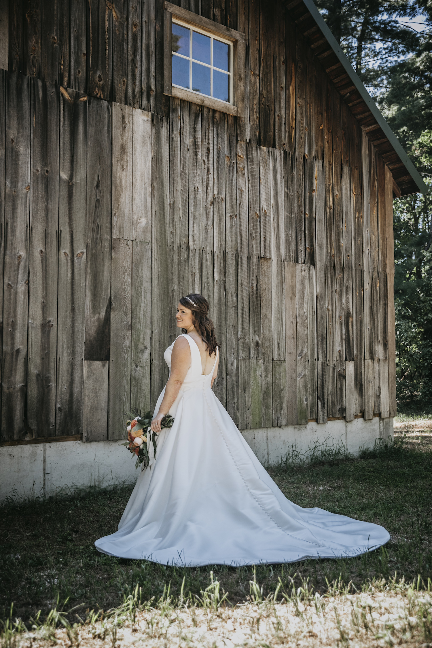 Bride standing by cabin at Higgins lake wedding