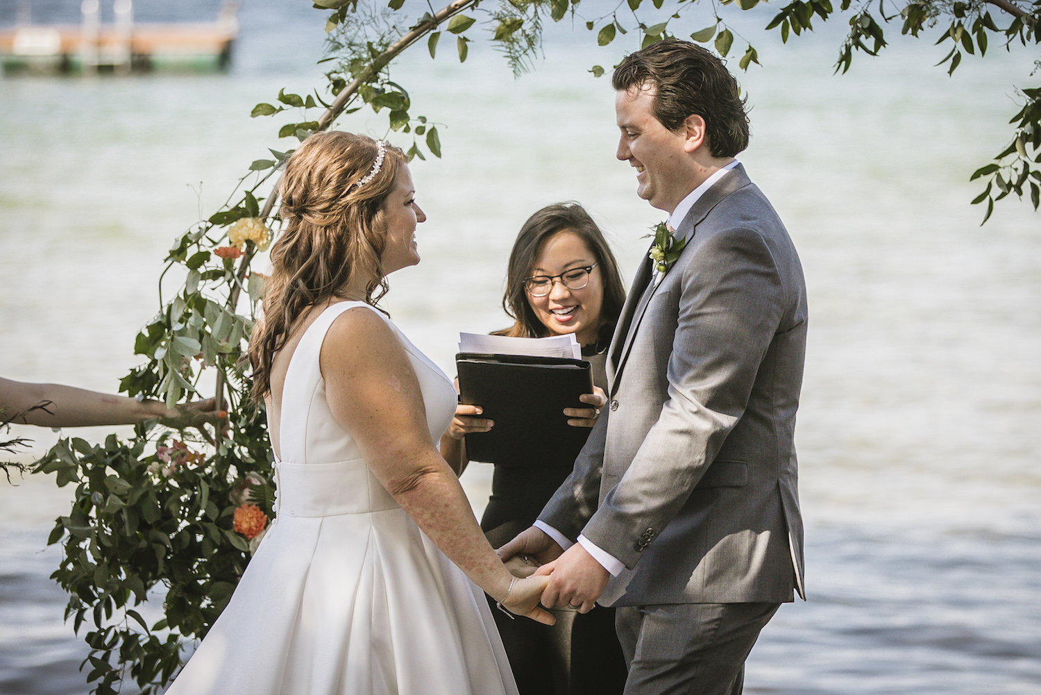 Bride and groom holding hands at alter of Higgins lake wedding