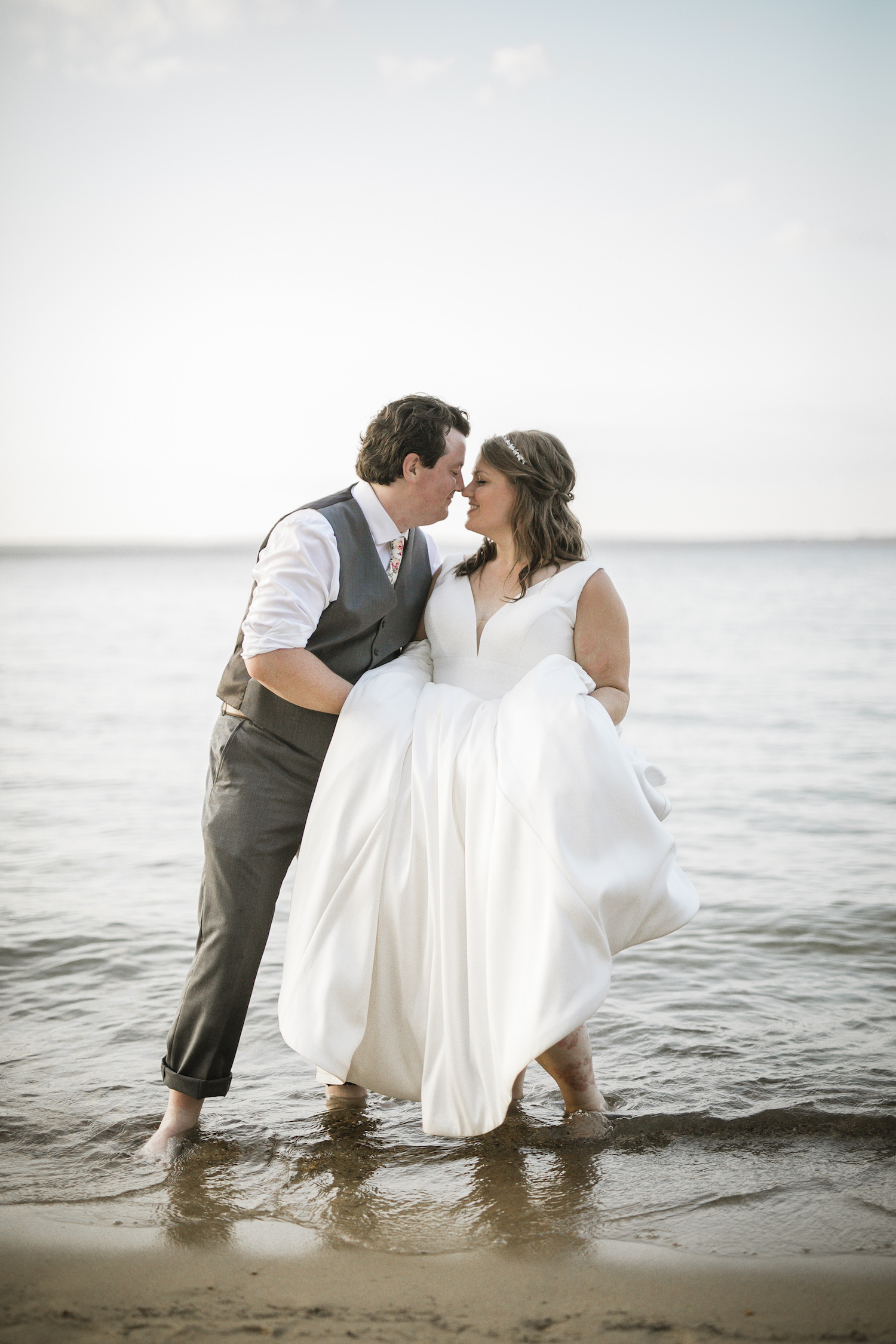 Bride and groom leaning into each other in the water