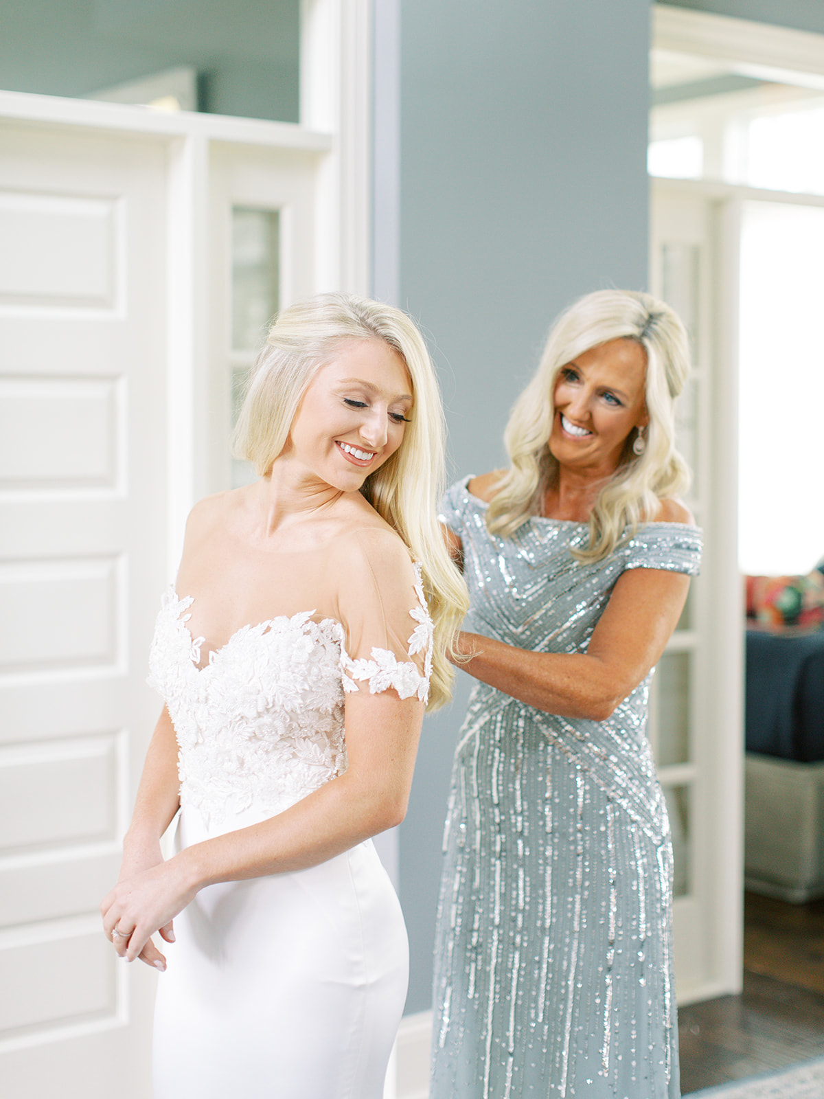 Mother of Bride buttoning bride's gown