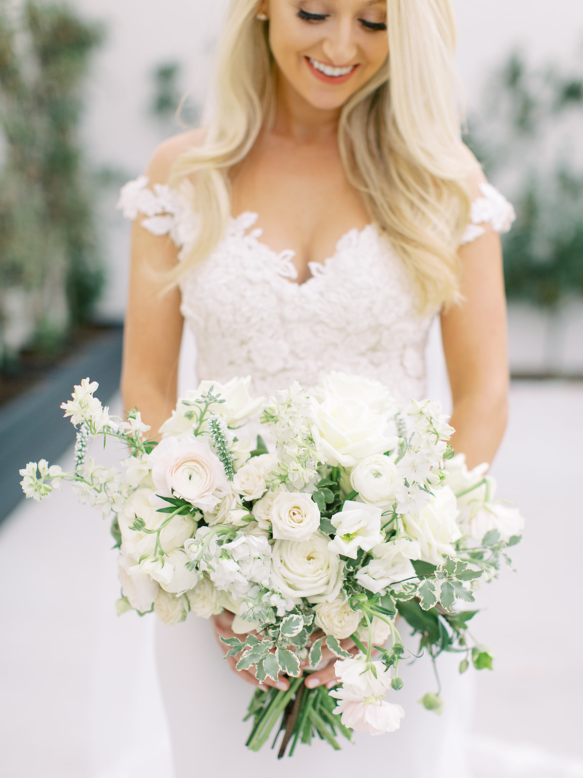 Bride smiling down at bouquet before Ritz Charles wedding