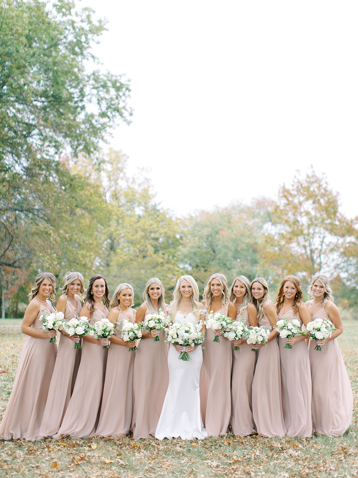 Bride standing with bridesmaids holding bouquets