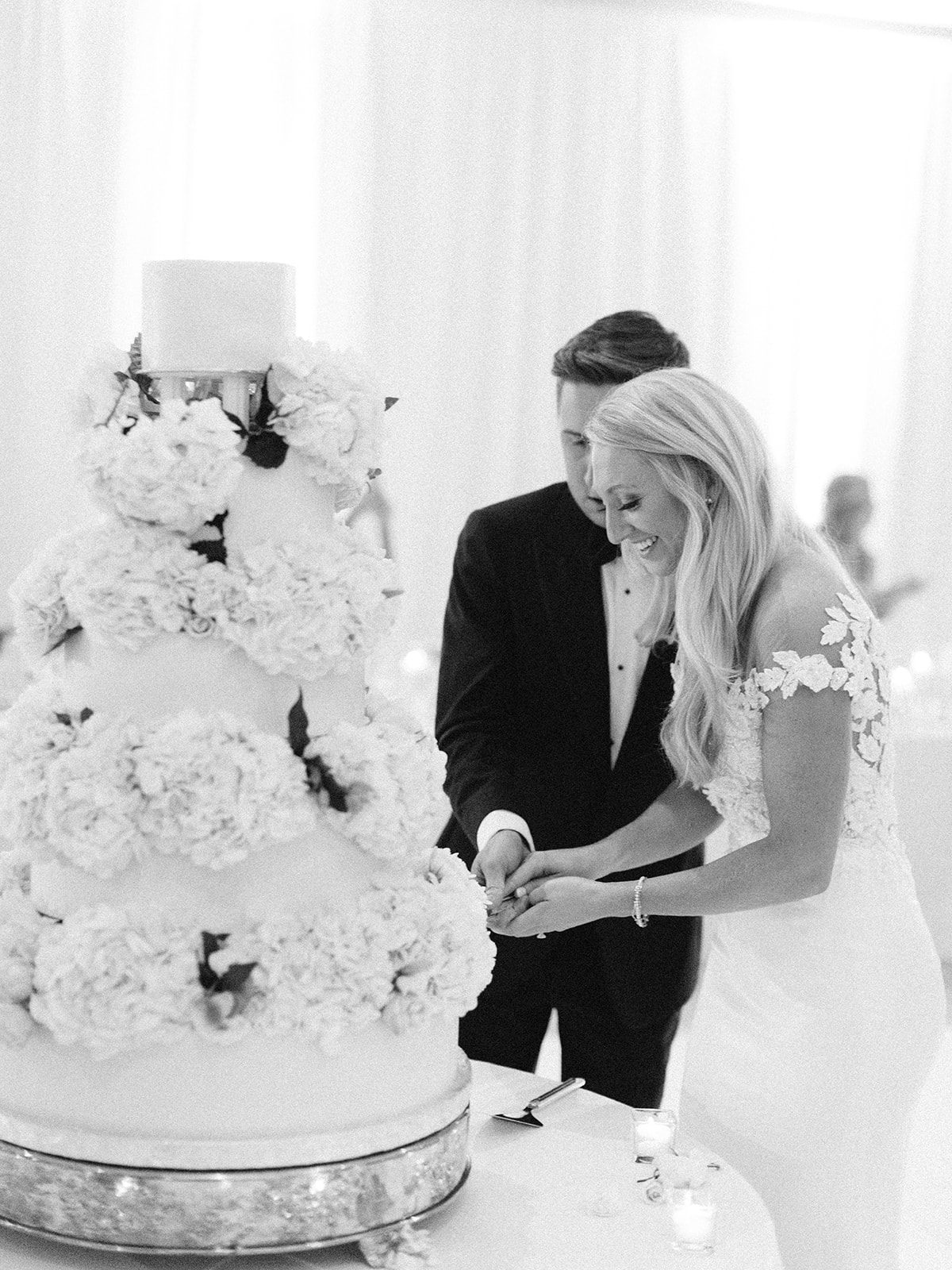 Bride and groom smiling cutting their cake