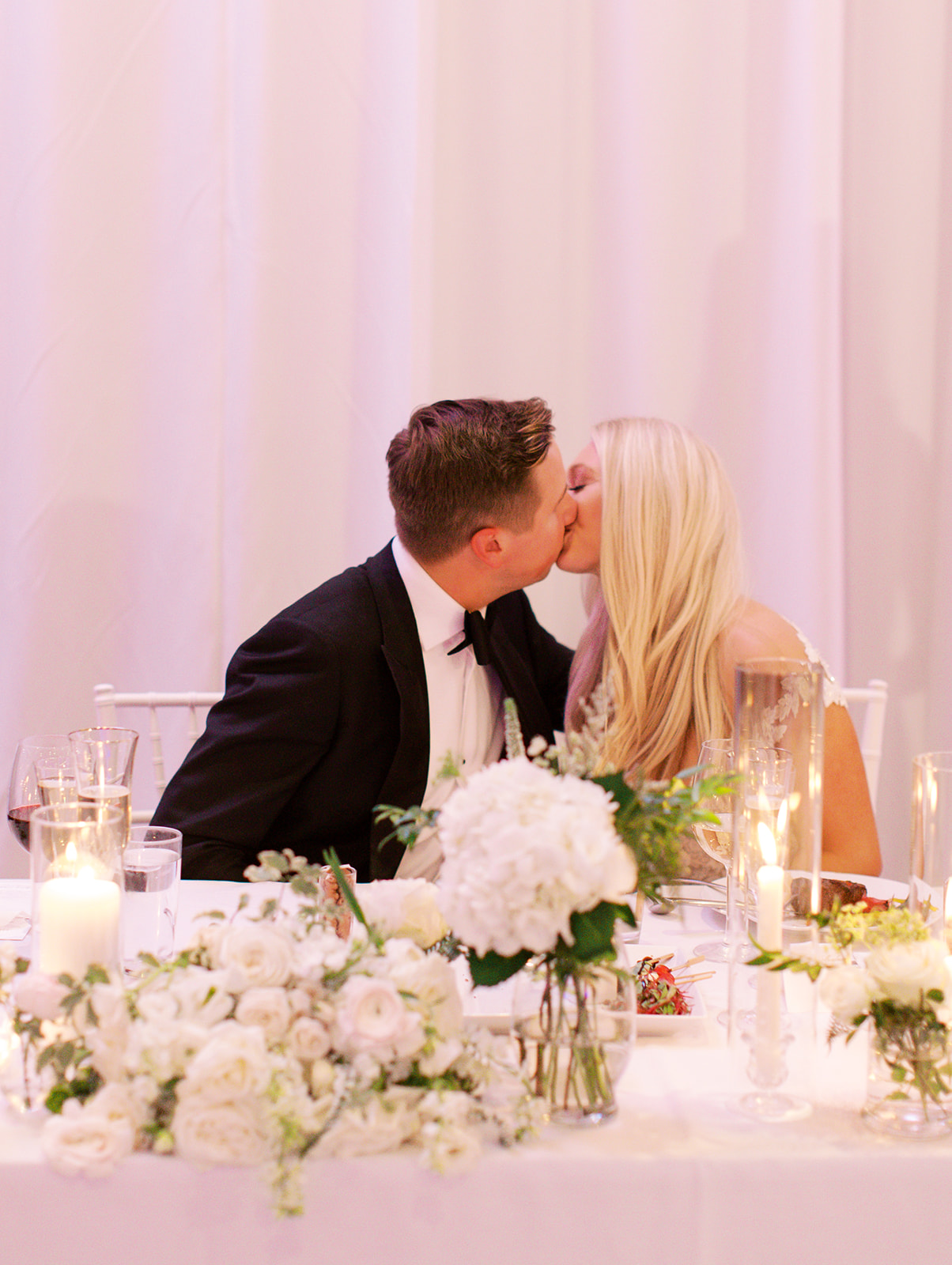 Bride and groom kissing at table