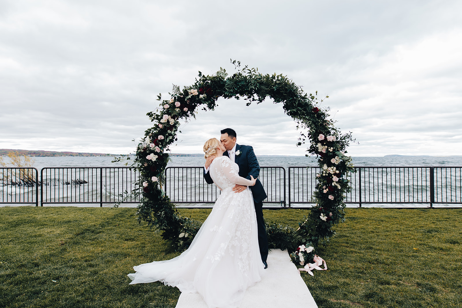 Groom kissing his bride at the hoop arch