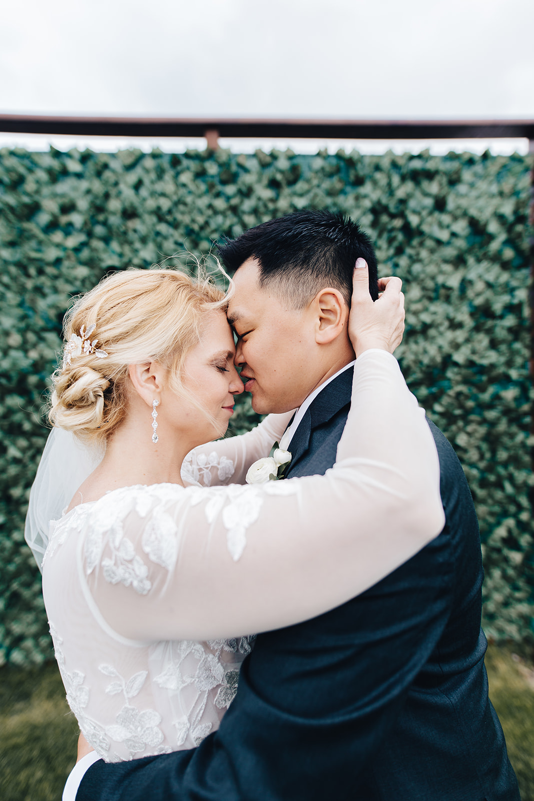 Bride and groom leaning foreheads together