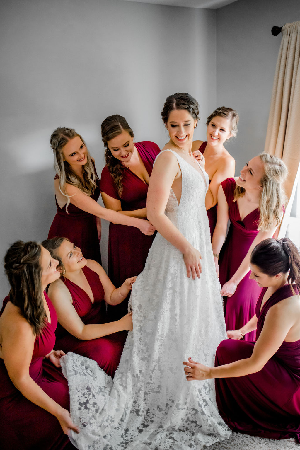 Bridal party admiring the brides gown before Jackson, MI wedding