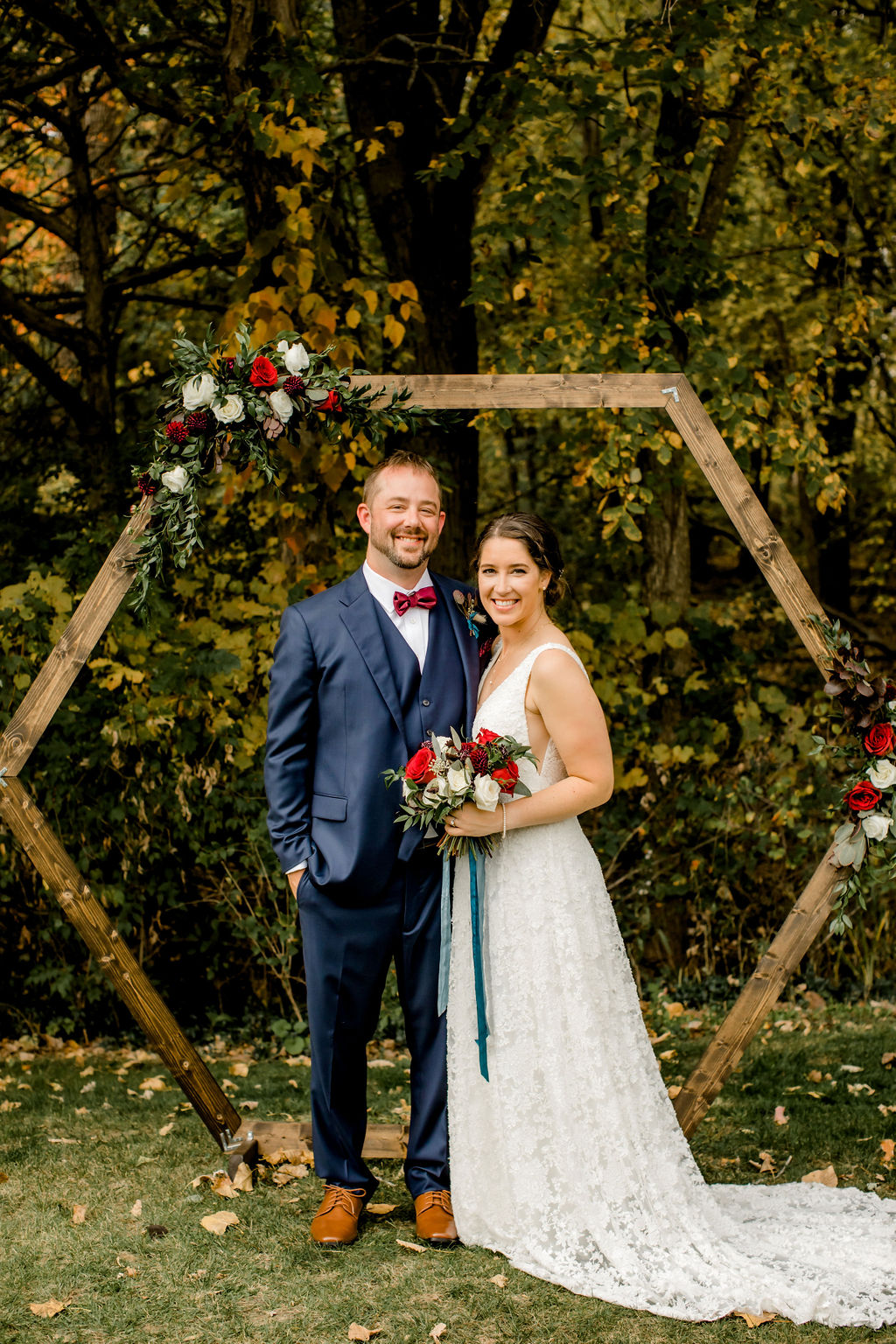 Bride and groom smiling at arch