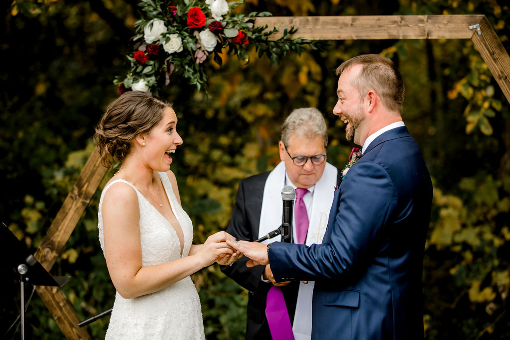 Bride putting ring on grooms hand