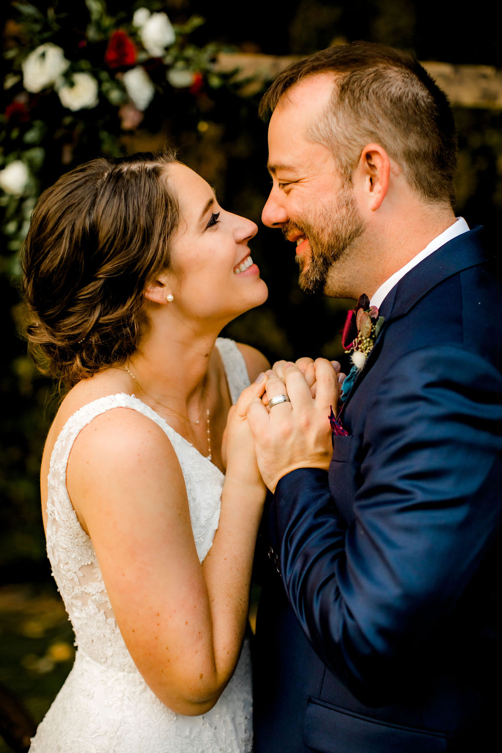 bride and groom holding hands smiling