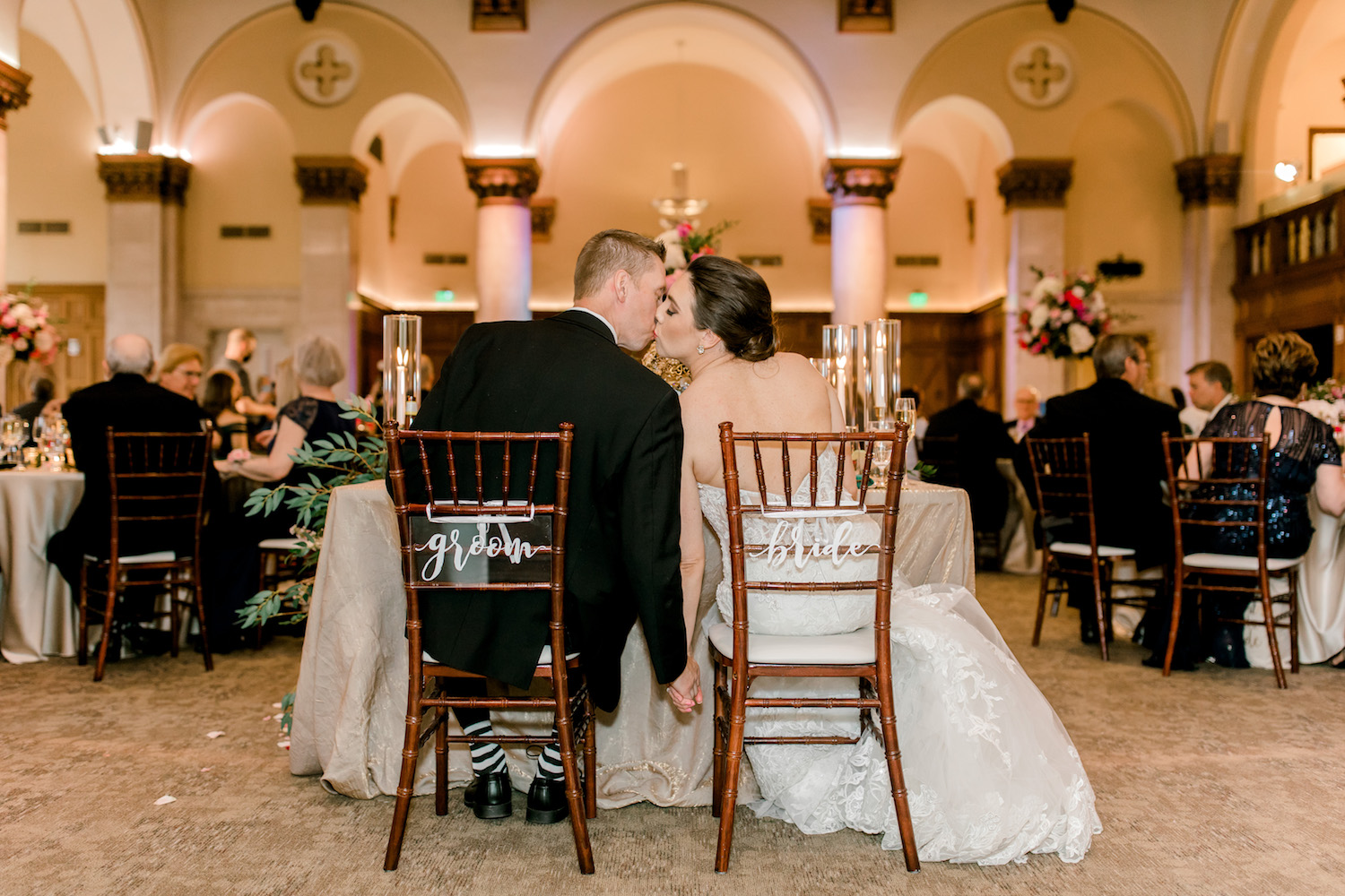 Bride and groom kissing at head table during City Flats Hotel wedding