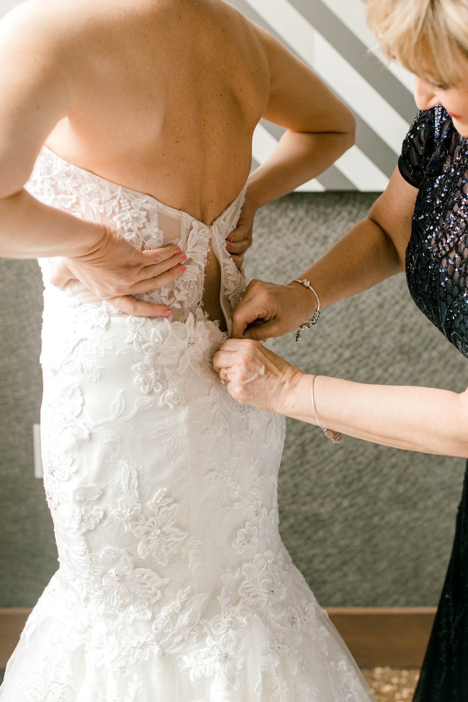 Brides dress being buttoned for her City Flats Hotel wedding