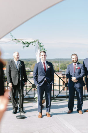 Groom watching his bride as they walks down the aisle during their Kalamazoo, Michigan wedding