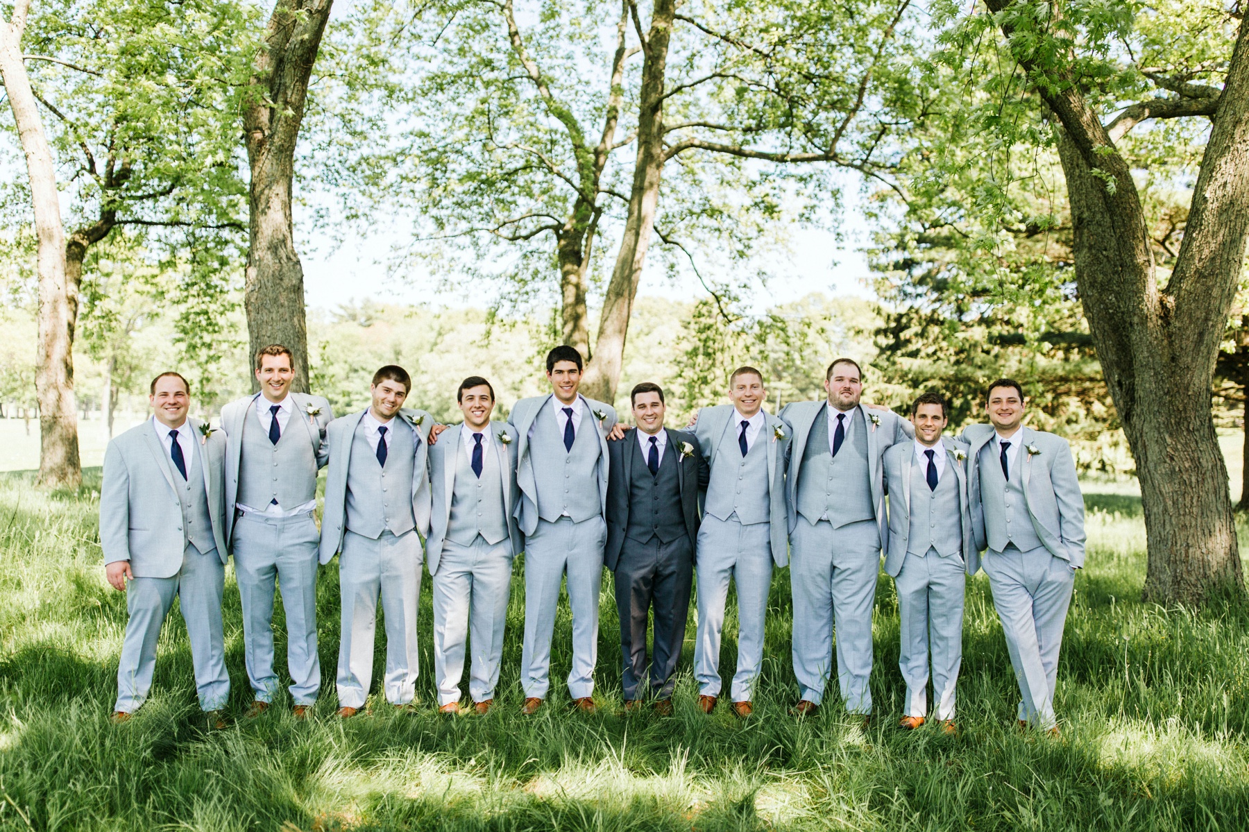 A groom and his groomsmen smiling before his Spring Lake, Michigan wedding