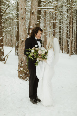 Couple smiling in the snow during their michigan winter wedding