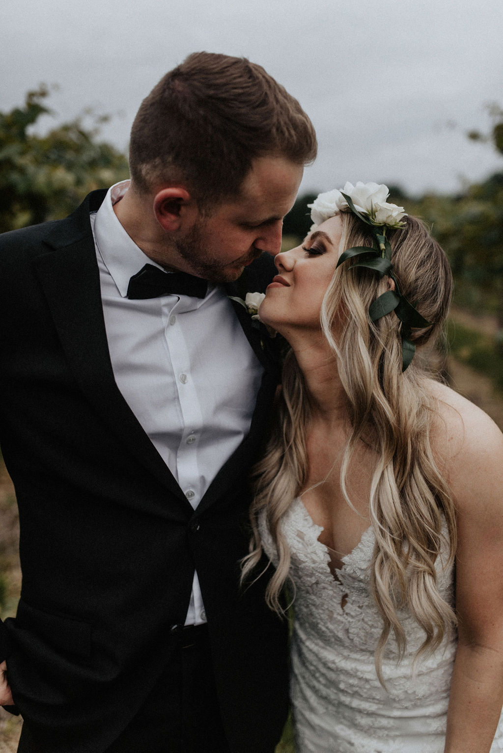 A couple kissing in the vineyard after their wedding