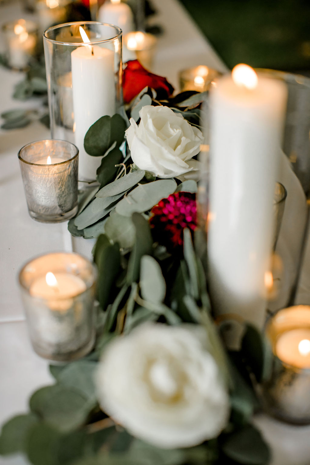 Candles and floral design on tables at Jackson, MI wedding